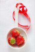 Three strawberries in a ladle