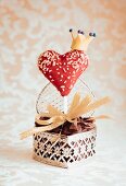 A heart-shaped cake pop decorated with a crown