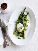 Green asparagus with poached eggs, garlic and sardine butter