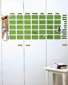 Calender made of green magnetic wafers on white cabinet fronts