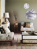 Sessel, Couchtisch, Wandkonsole und runde Prints in einem Wohnzimmer mit Taupe Wandfarbe