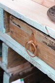 Wooden drawer with rusty handle in wooden shelving