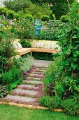 Secluded seating area in garden with wooden bench and cushions