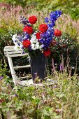 Sommerlicher Blumenstrauss im Zinkeimer auf Gartenstuhl