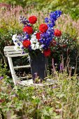 Summer bouquet in a zinc pail on a garden chair