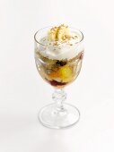 An ice cream sundae with fruit salad and cream