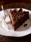 A slice of chocolate tart with chocolate curls