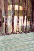 View through thread curtain in various shades of red