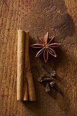 Cloves, cinnamon sticks and star anise on a wooden surface