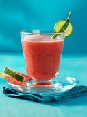 Watermelon smoothie garnished with chilli peppers and limes