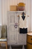 White-washed, vintage wardrobe with carved ornamentation in bedroom