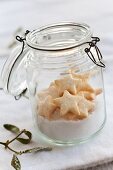 Sugar and star-shaped biscuits in a flip-top jar with a sprig of mistletoe