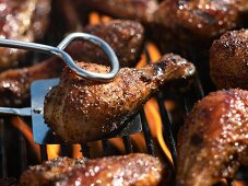 Pepper Jelly Chicken Drumsticks on the Grill; Tongs Flipping Drumstick