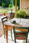 Rustikaler Tisch und Stühle auf Terrasse mit Blick in Garten
