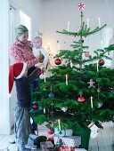 Family with child decorating Christmas tree