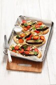 Pita bread pizza topped with aubergines, tomatoes and feta cheese