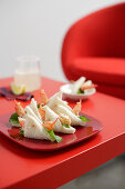 Prawn sandwiches on a red plate on a red table