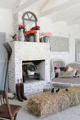 Living room with bale of hay serving as a table and brick-built fireplace