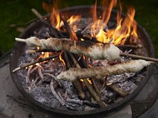 Stick bread being grilled on an open fire