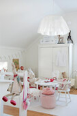 Scandinavian-style child's bedroom - soft toys on white chairs around table in front of white wardrobe