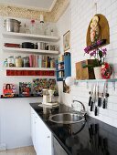 Küchenzeile mit glänzender, schwarze Arbeitsplatte in traditionellem Ambiente