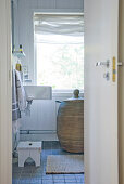 Blick durch offene Tür auf Rattan Wäschekorb im Badezimmer