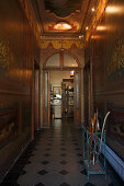 Grand hallway with arched doorway and painted wooden panelling on walls and ceiling