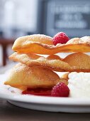 French carnival pastries with raspberries, raspberry sauce and cream