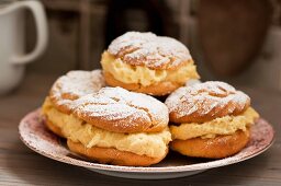 Profiteroles filled with vanilla cream and dusted with icing sugar