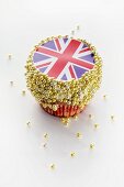 A cupcake decorated with a Union Jack and sugar balls