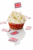 A cupcake decorated with golden beads and a Union Jack