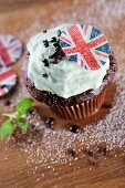A chocolate cupcake topped with mint cream and a Union Jack