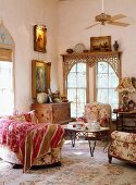 Romantic, antique sitting area with floral upholstered furniture and vintage chest of drawers in front of a lattice window with an oriental touch