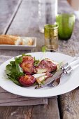 Brie wrapped in bacon with roasted plums and pesto sauce