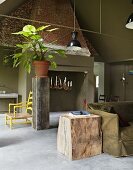 Wood block furniture and chandelier in old fireplace in smoking room with khaki green walls