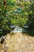 Two chairs on small balcony with view of garden