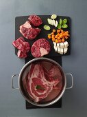 Soup vegetables being cut and meat being cooked