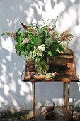 Hand-picked bouquet on rusty garden table against exterior wall