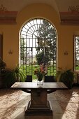 Antique wooden table on old stone floor in foyer of villa