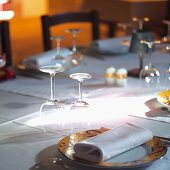 Place setting with linen napkin and wine glasses on white tablecloth