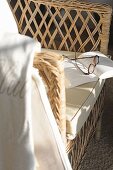 Glasses and book on wicker chair