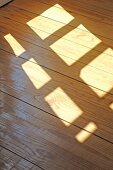Sonne scheint durch ein Fenster auf Holzfußboden