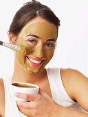 Woman applying healing earth face mask