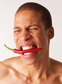 Man biting on hot pepper