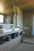 Designerbad - Gemauerter Waschtisch mit teilweise offenem Regal und Schubladen neben Glastrennscheibe vor Dusche