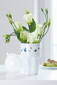 Butterfly-patterned tape on vase of white Texas bluebells (Eustoma grandiflorum)