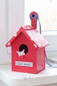 Romantic, pink bird box with label reading 'Sweet home' and tape spots