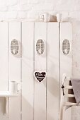 White wooden wall with hooks and gingerbread heart