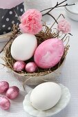 Easter arrangement with straw nest in dish, Easter eggs, chocolate eggs and paper flowers