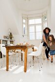 Mother, daughter and dog running through a kitchen